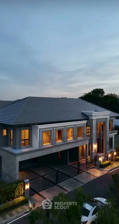 Luxurious two-story home with elegant facade and ambient evening lighting