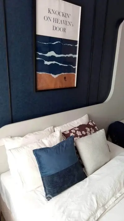 Stylish bedroom with modern decor and cozy pillows, perfect for relaxation.