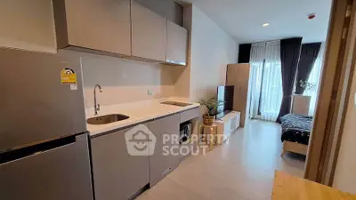 Modern studio apartment with sleek kitchen and cozy bedroom area