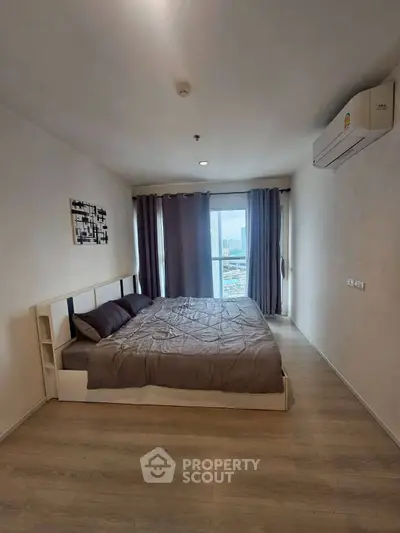 Modern bedroom with city view, featuring a cozy bed and air conditioning.
