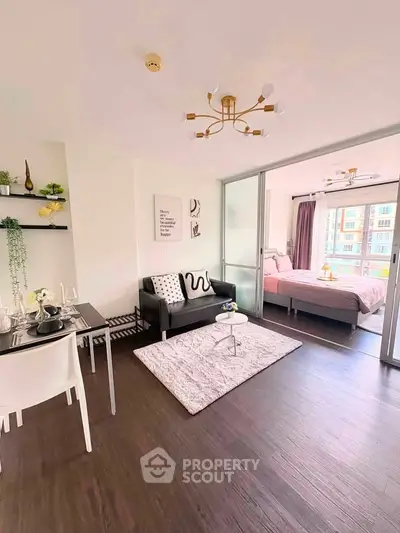 Modern open-plan living room with stylish decor and sliding doors to a cozy bedroom.