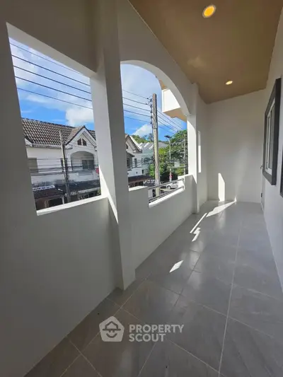 Spacious balcony with modern design and great view of neighborhood houses.
