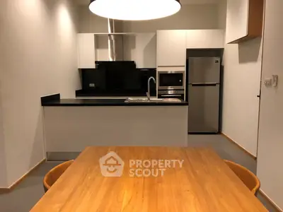 Modern kitchen with sleek design, featuring stainless steel appliances and a stylish dining area.