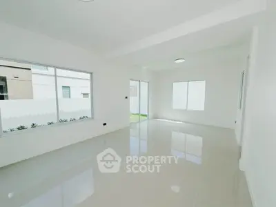Spacious modern living room with large windows and glossy tiled floors