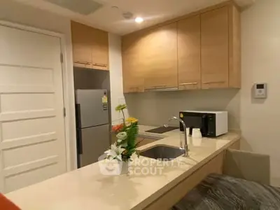 Modern kitchen with sleek cabinetry and integrated appliances in a cozy apartment.