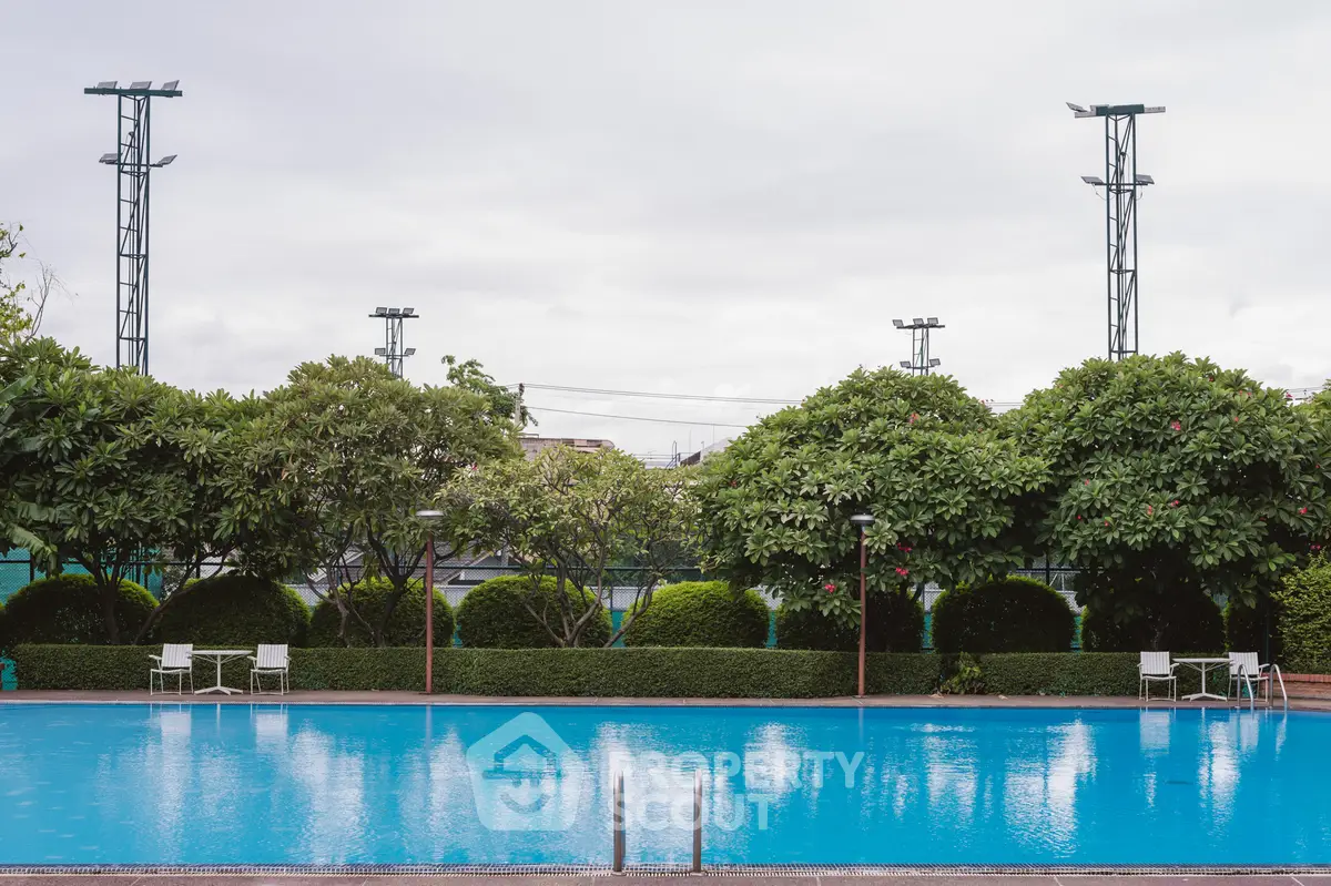 Luxurious outdoor pool surrounded by lush greenery, perfect for relaxation and leisure.