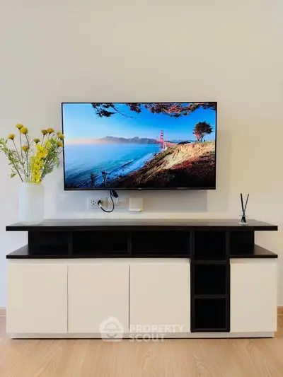 Modern living room with sleek TV stand and wall-mounted flat-screen TV, perfect for entertainment.