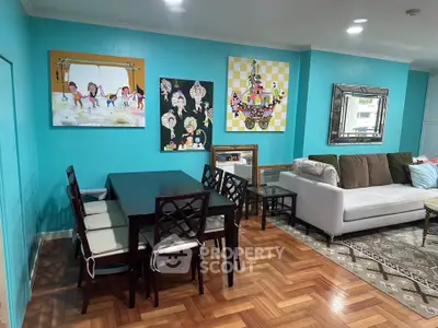 Charming living room with vibrant artwork and cozy seating area, perfect for family gatherings.