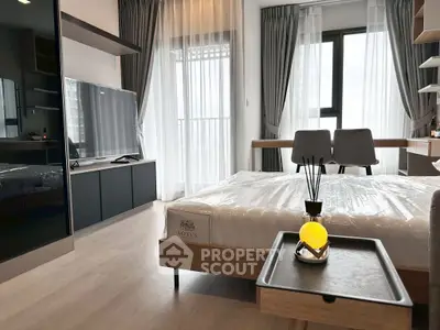 Modern bedroom with sleek furniture and large window offering natural light