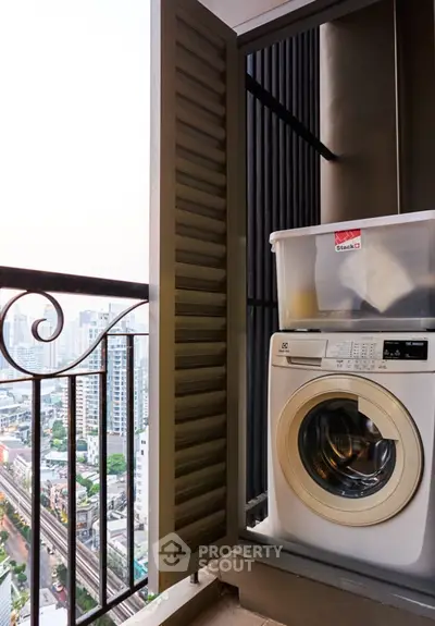 High-rise balcony with washing machine and city view, perfect for urban living.