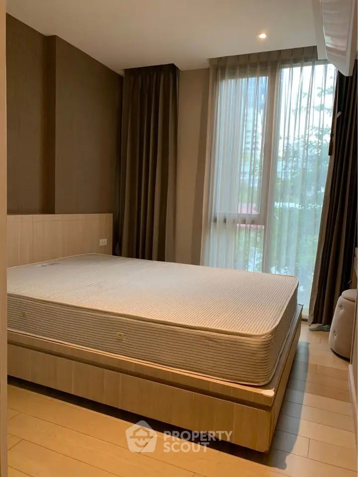 Cozy bedroom with large window and modern decor in a stylish apartment.