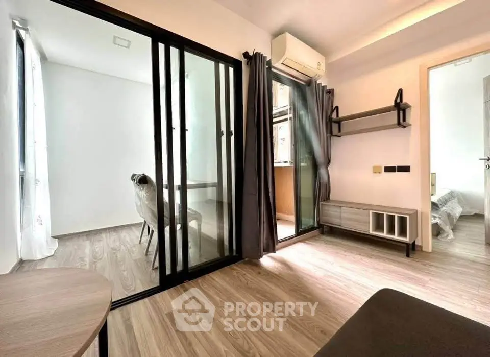 Modern living room with sliding glass doors and wooden flooring in a stylish apartment.