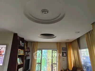 Spacious living room with modern ceiling design and large windows offering natural light.