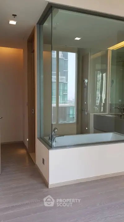 Modern bathroom with glass-enclosed shower and bathtub in luxury apartment