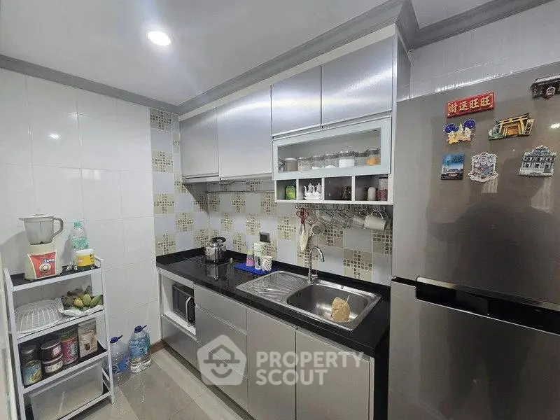 Modern kitchen with sleek cabinets and stainless steel appliances, featuring a compact yet efficient layout.
