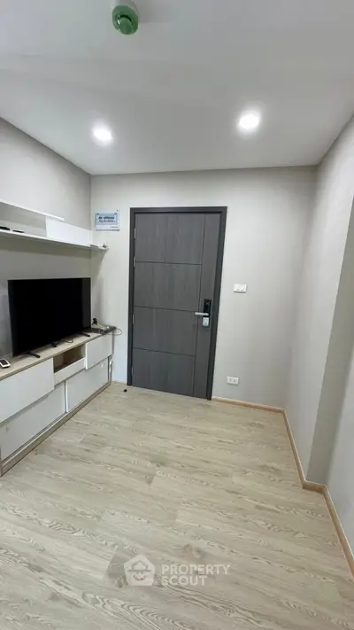 Modern apartment entrance with sleek wooden door and entertainment unit