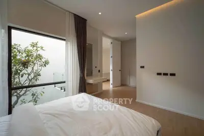Modern minimalist bedroom with large window and natural light