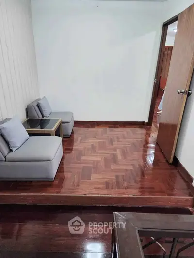 Cozy small living area with wooden flooring and modern seating