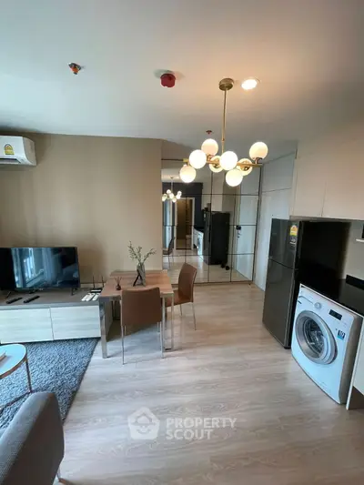 Modern living room with dining area, TV, and washing machine in a stylish apartment.