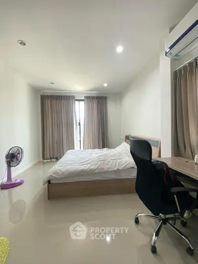 Spacious bedroom with modern furnishings and natural light