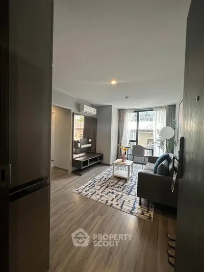 Modern living room with stylish decor and large windows offering natural light.