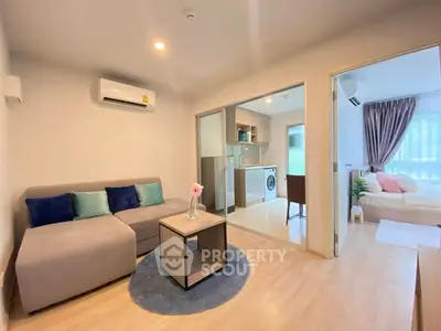 Modern living room with cozy sofa, open kitchen, and bright bedroom in stylish apartment.