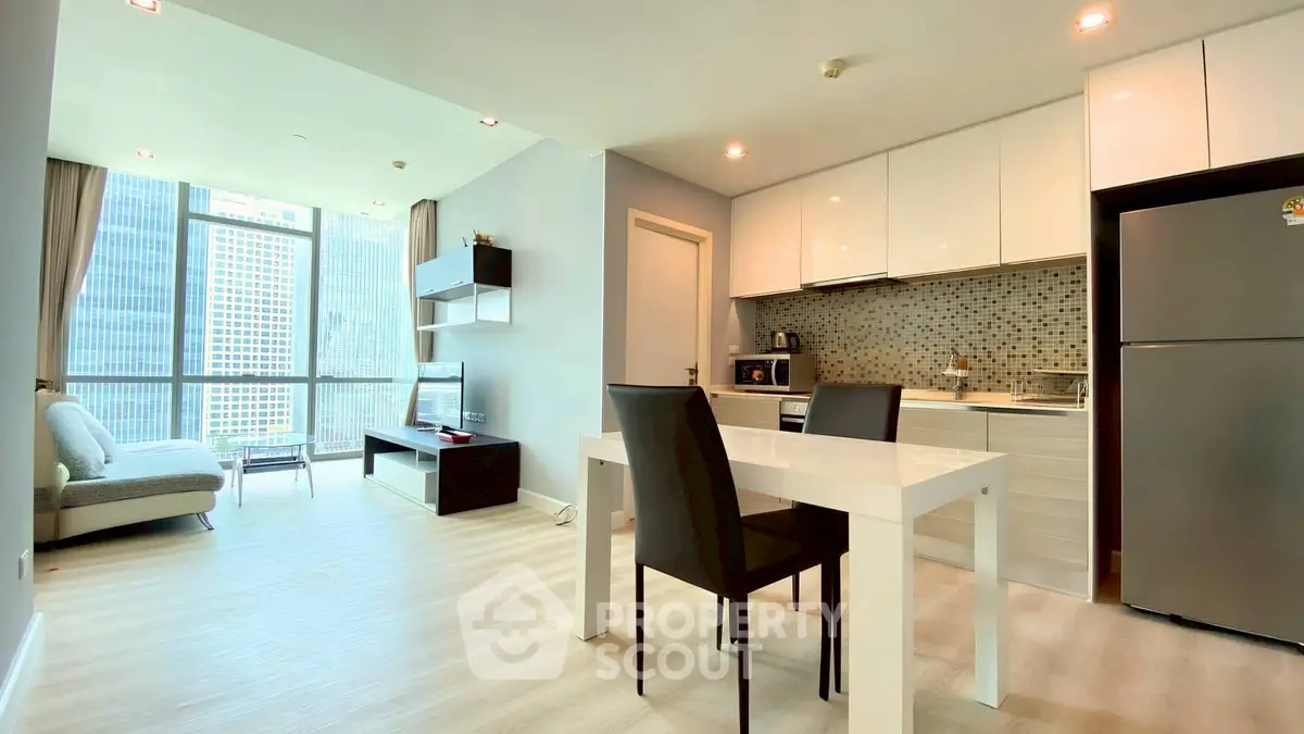 Modern open-plan living room and kitchen with sleek design and city view.