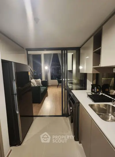 Modern kitchen with sleek appliances and open view to stylish living room