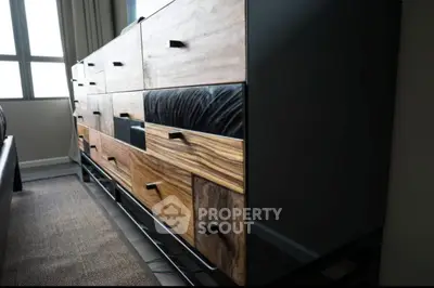 Stylish modern dresser with mixed wood drawers in a contemporary bedroom setting.