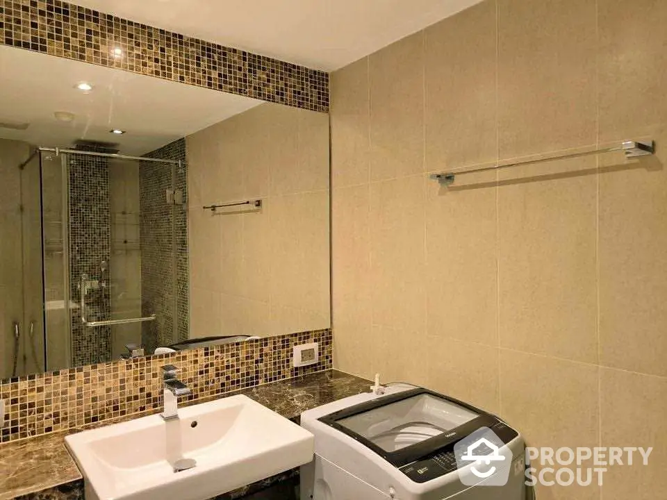 Modern bathroom with washing machine and stylish mosaic tiles