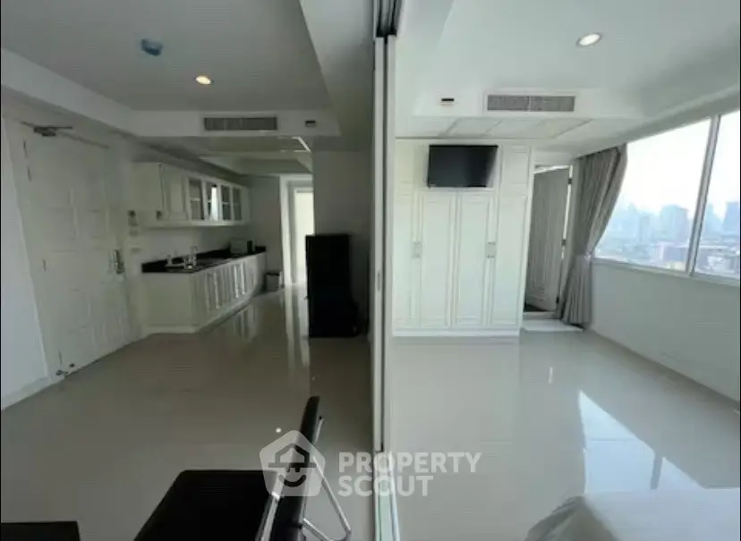 Spacious modern apartment with sleek kitchen and city view, ideal for urban living.