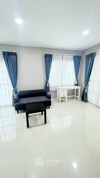 Bright and spacious living room with modern furniture and large windows.