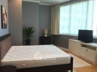 Spacious bedroom with large window and modern decor in a stylish apartment.