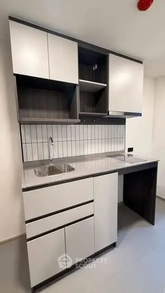 Modern compact kitchen with sleek cabinetry and integrated sink, perfect for urban living.