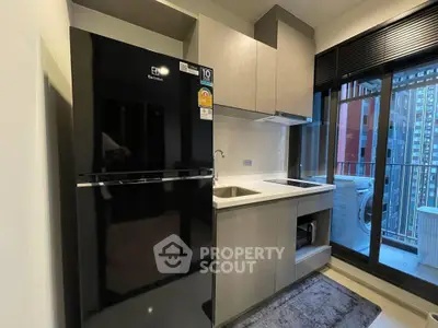 Modern kitchen with sleek appliances and balcony view in urban apartment