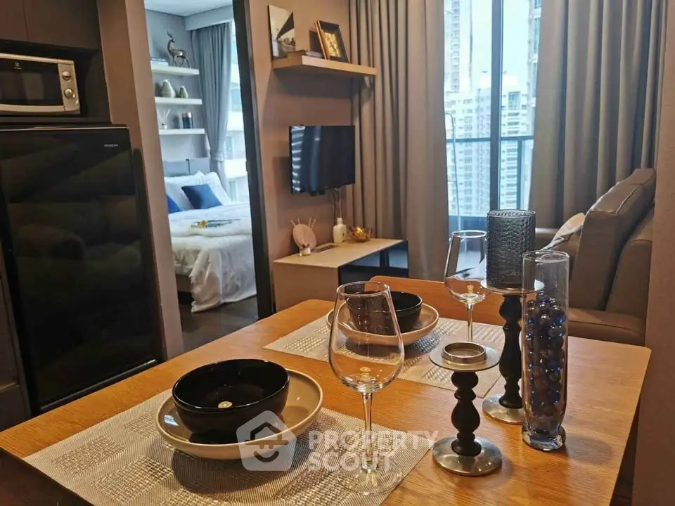Modern apartment interior with open kitchen and cozy living area, featuring stylish decor and city view.