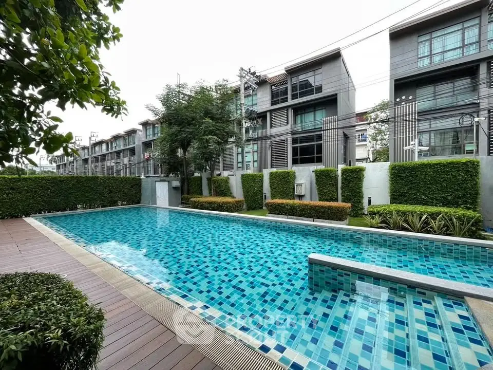 Luxurious residential complex with a pristine swimming pool and modern architecture.
