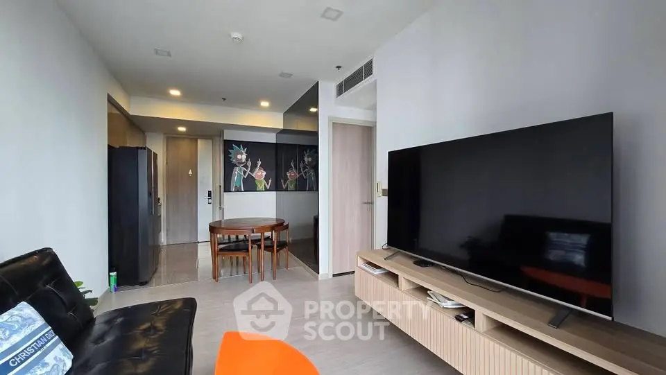 Modern living room with sleek furniture and large TV, perfect for relaxation and entertainment.