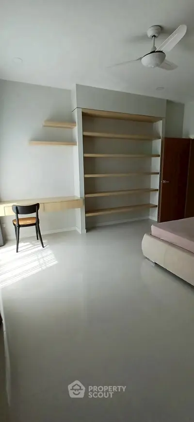 Spacious bedroom with modern shelving and natural light