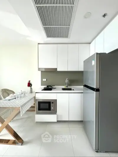 Modern kitchen with sleek white cabinets and stainless steel appliances