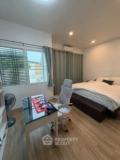 Modern bedroom with study area, featuring a sleek desk and comfortable chair, perfect for work and relaxation.