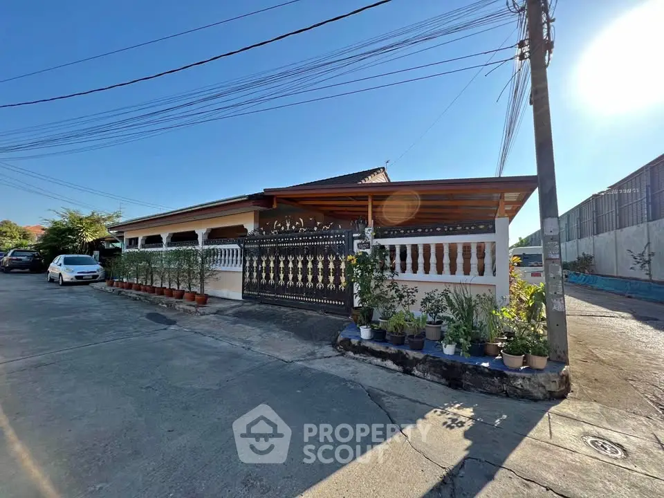 Charming single-story house with gated entrance and potted plants, perfect for family living.