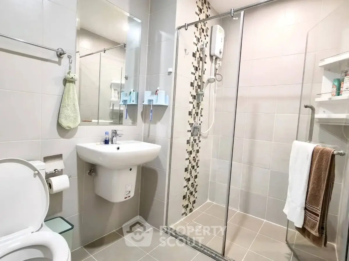 Modern bathroom with glass shower and sleek fixtures in a contemporary apartment.