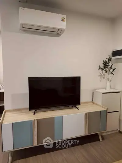 Modern living room with stylish TV stand and air conditioning unit, perfect for cozy entertainment.