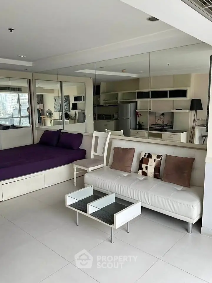 Modern studio apartment with mirrored walls and sleek furniture in urban setting.