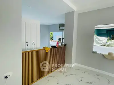 Modern interior with sleek wooden paneling and marble flooring, featuring large windows for natural light.