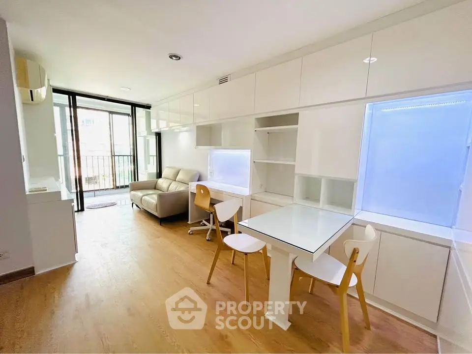 Modern living room with sleek furniture and natural light, featuring a cozy sofa and stylish dining area.