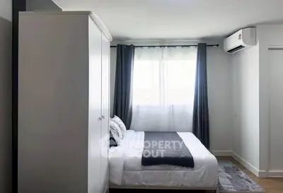 Modern bedroom with sleek design, featuring a cozy bed, wardrobe, and air conditioning unit.