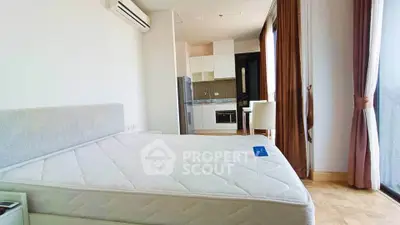 Modern bedroom with kitchen view, featuring large windows and elegant decor.