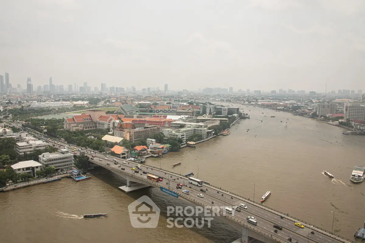 Stunning aerial view of a bustling cityscape with river and bridge, showcasing urban living and connectivity.
